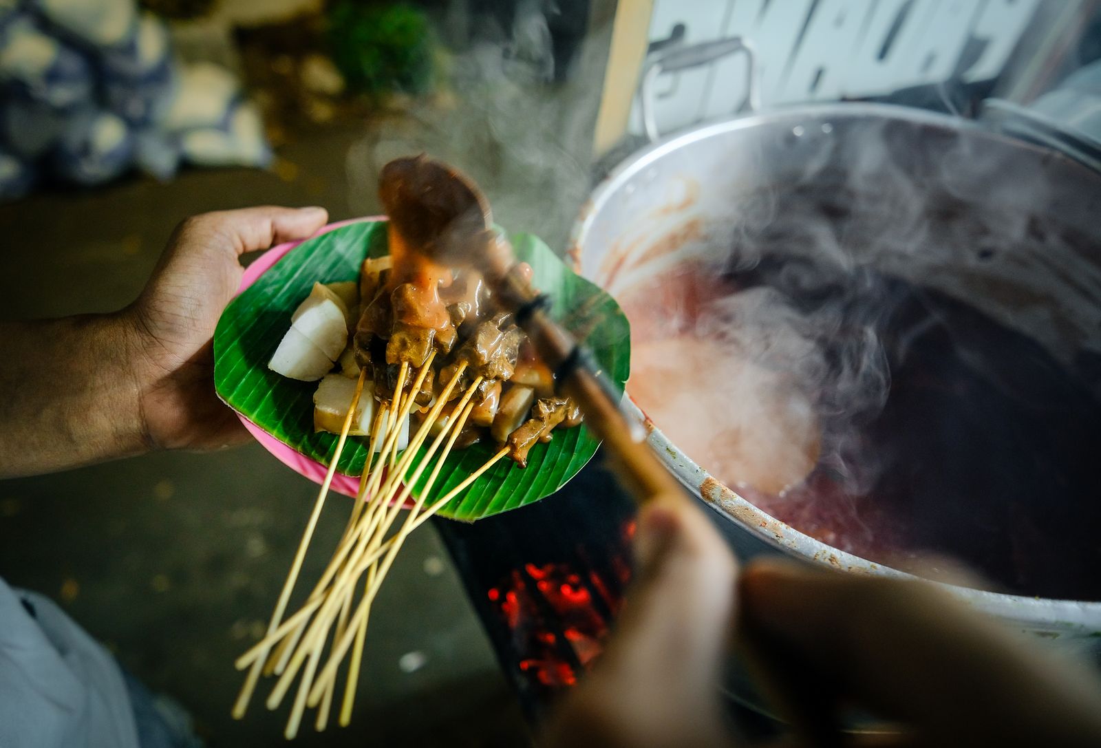 Indonesian satay served with peanut sauce on a banana leaf.