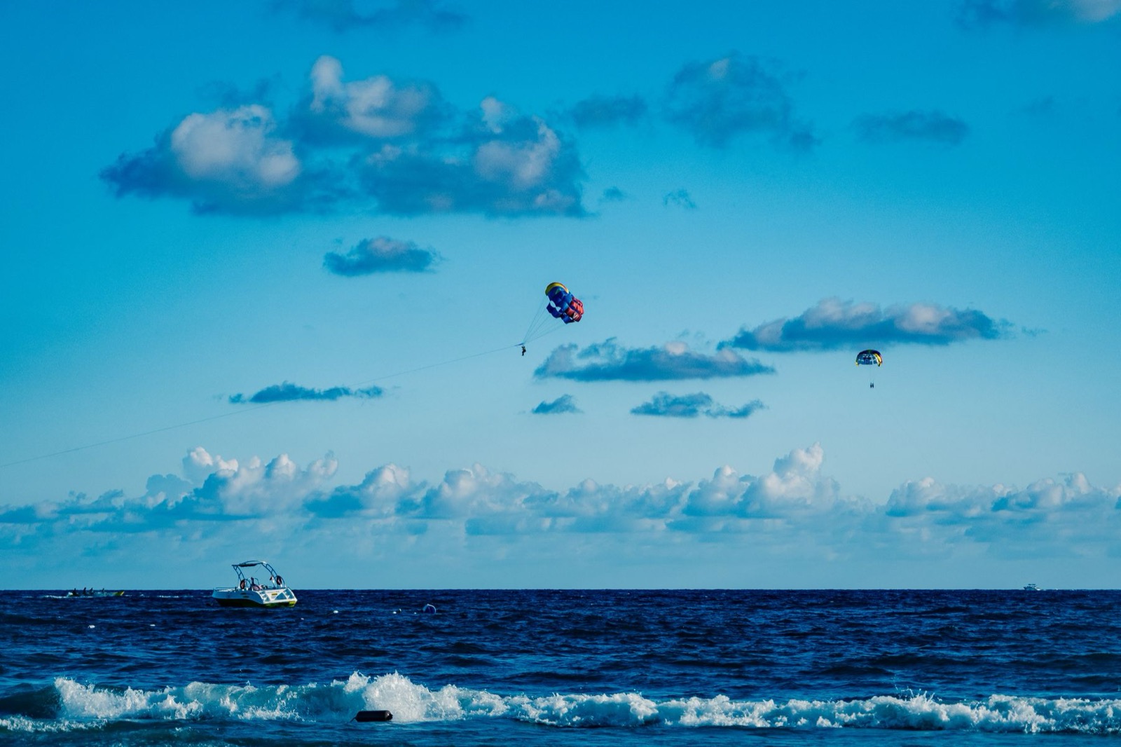 Parasailing over the sea with the tow boat below.
