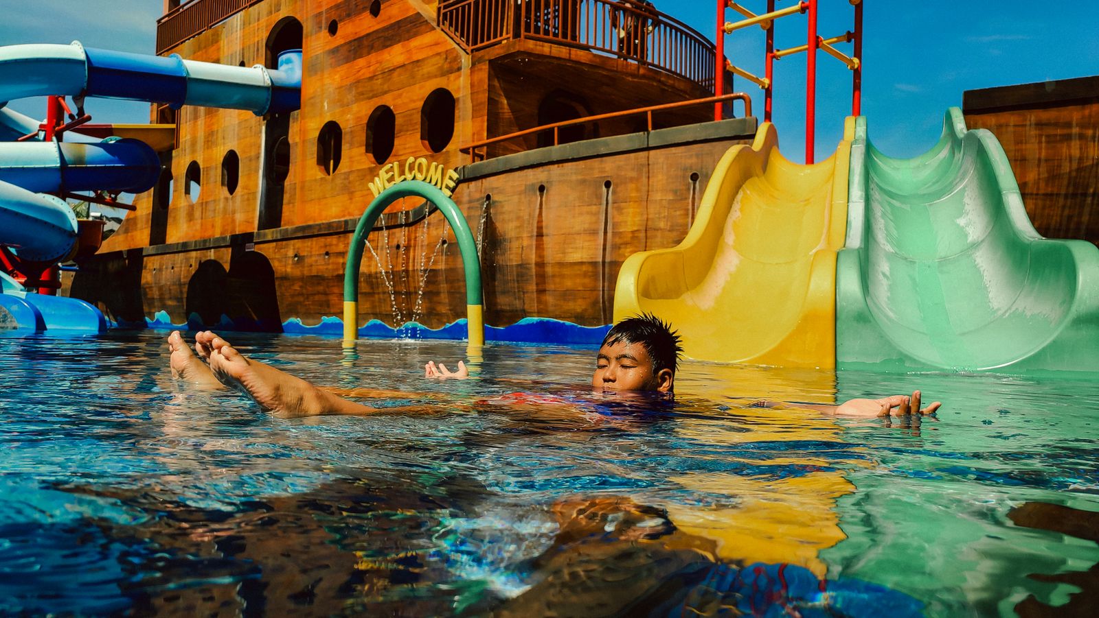 A child floating in a water park pool, Indonesia.